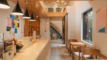 A modern interior with a kitchen area, wooden furniture, and a staircase leading to an upper level.