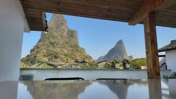 A room with a wooden ceiling and a view of mountains.