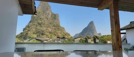 A room with a wooden ceiling and a view of mountains.