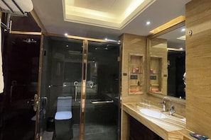 A modern bathroom with a glass-enclosed shower, a large mirror, and a marble countertop. - Shishi Wanjia International Hotel (Shishi)
