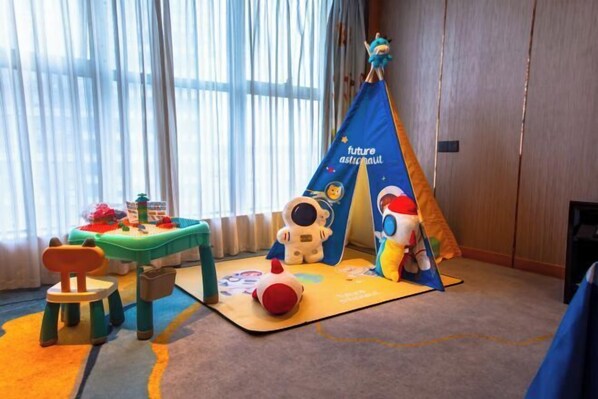 A child's play area with a table, chairs, a play mat, and a tent labeled 'future astronaut.' - Shishi Wanjia International Hotel (Shishi)