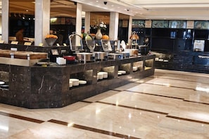 Un espace buffet doté d’un comptoir en marbre et proposant divers plats.