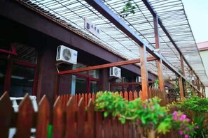 Un bâtiment doté d’un toit en métal, de climatiseurs et d’une clôture en bois.