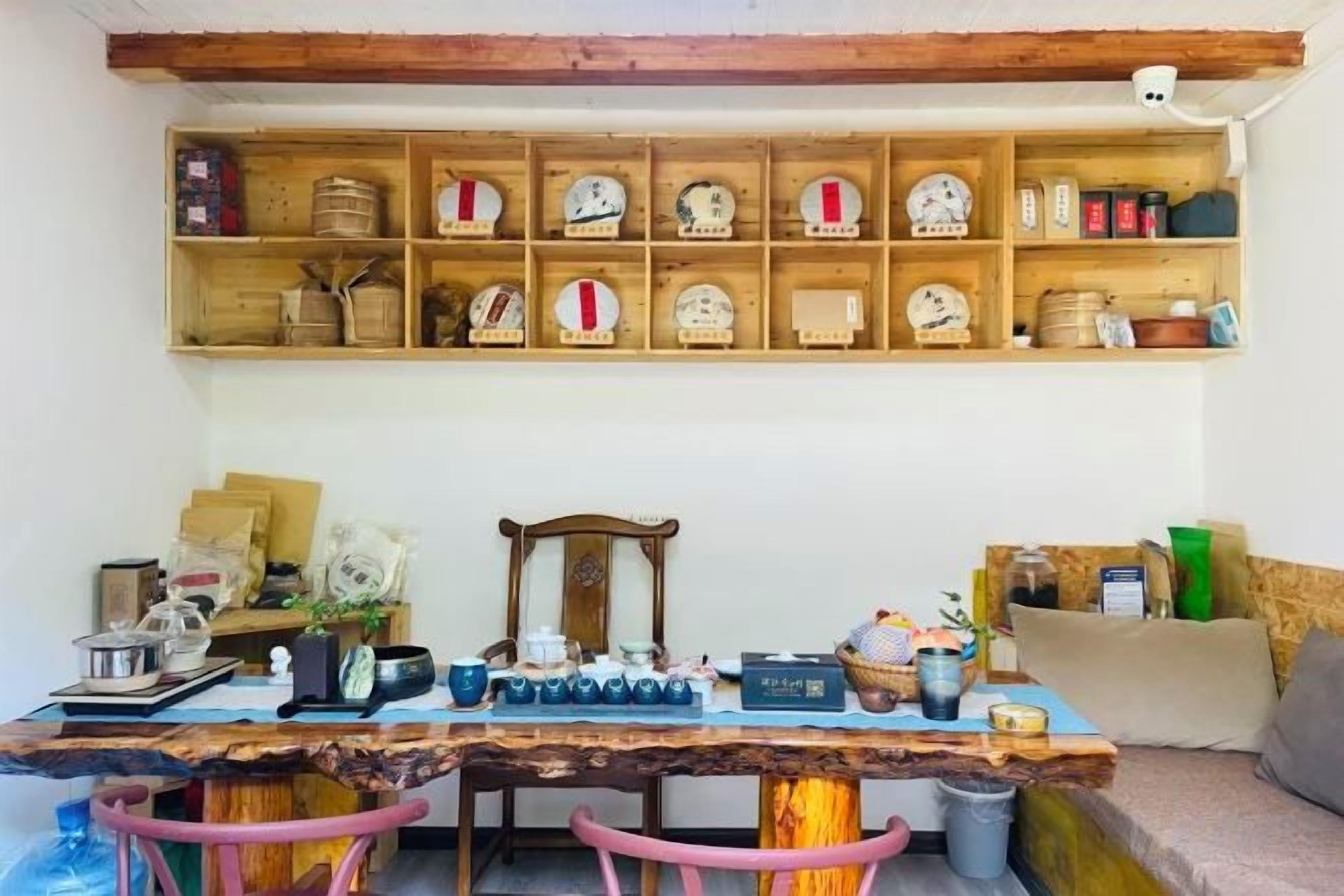 Uma área de refeições rústica com mesa de madeira, cadeiras e um armário com utensílios de cozinha.
