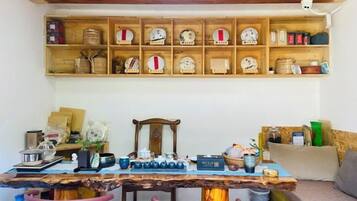 Uma área de refeições rústica com mesa de madeira, cadeiras e um armário com utensílios de cozinha.