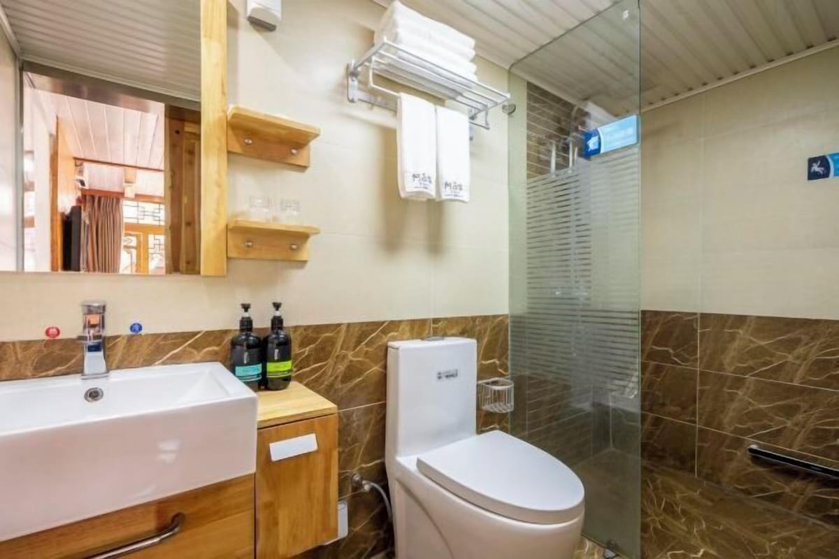 Une salle de bain comprenant un lavabo, des toilettes et un espace douche.