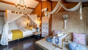 A room with a bed, a small table, and a seating area with cushions. - Lijiang Aduke Inn (Lijiang Ancient City Mufu Branch) (Lijiang)