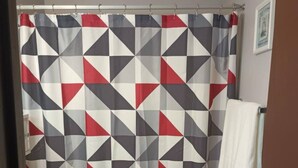 A bathroom with a geometric patterned shower curtain, a toilet, and a towel rack. - This apartment is a 1 bedroom(s), 1 bathrooms, located in Pierre, SD. (Pierre)
