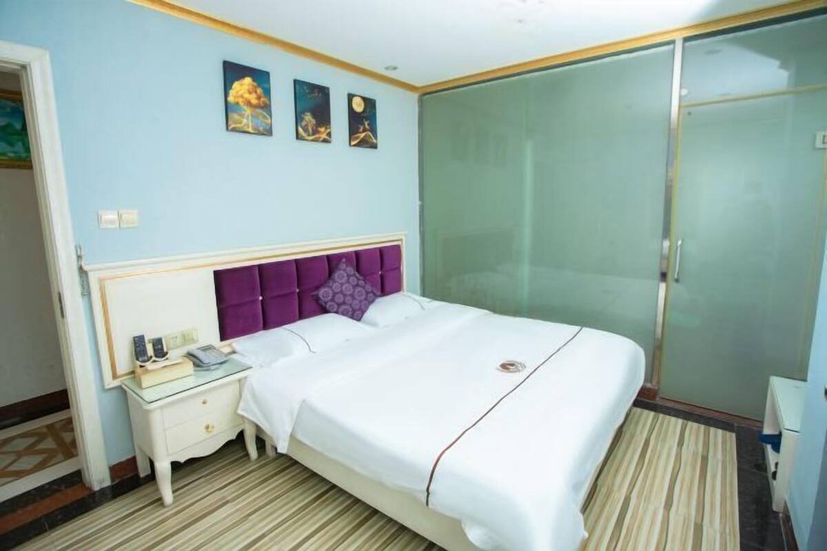 A bedroom with a bed, nightstand, and a wardrobe.