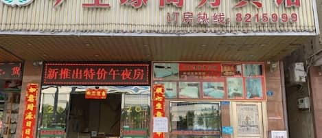 Fachada de un comercio con un letrero que muestra el nombre del negocio y un número de contacto.