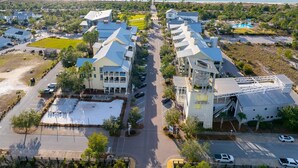 An aerial view of a coastal hotel with multiple buildings, a parking lot, and a view of the ocean. - Backwater Bliss (Port St. Joe)