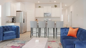 A modern living room with a blue sofa, a coffee table, and a colorful rug. - Backwater Bliss (Port St. Joe)