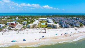 Ein Luftbild eines Küstenresorts mit Strandhäusern, einer Promenade und freiem Blick auf den Ozean.