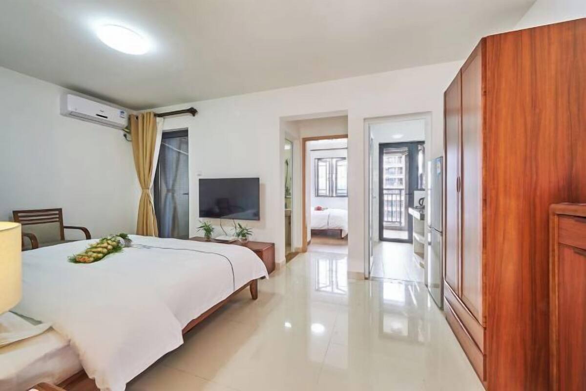 A hotel room with a bed, a TV, a desk, and a wardrobe.