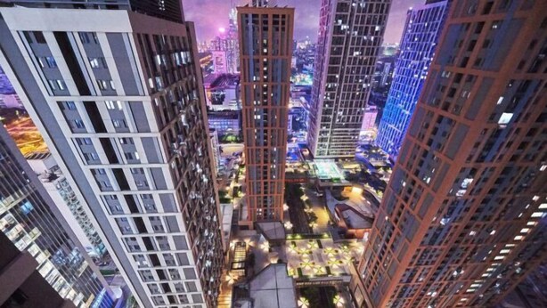 A high-rise urban area with multiple buildings, including a prominent red tower, surrounded by other high-rise structures. - Shanghe Apartment (Shenzhen Science and Technology Park MixC World) (Shenzhen)