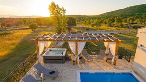 A rooftop pool area with a hot tub, lounge chairs, and a pergola with a view of the surrounding landscape. - Villa Unika heated Pool, Jacuzzi, Sauna (Opanci)