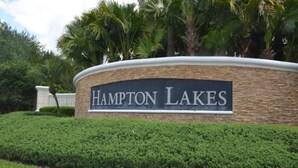Un área ajardinada con un letrero que dice 'Hampton Lakes'.