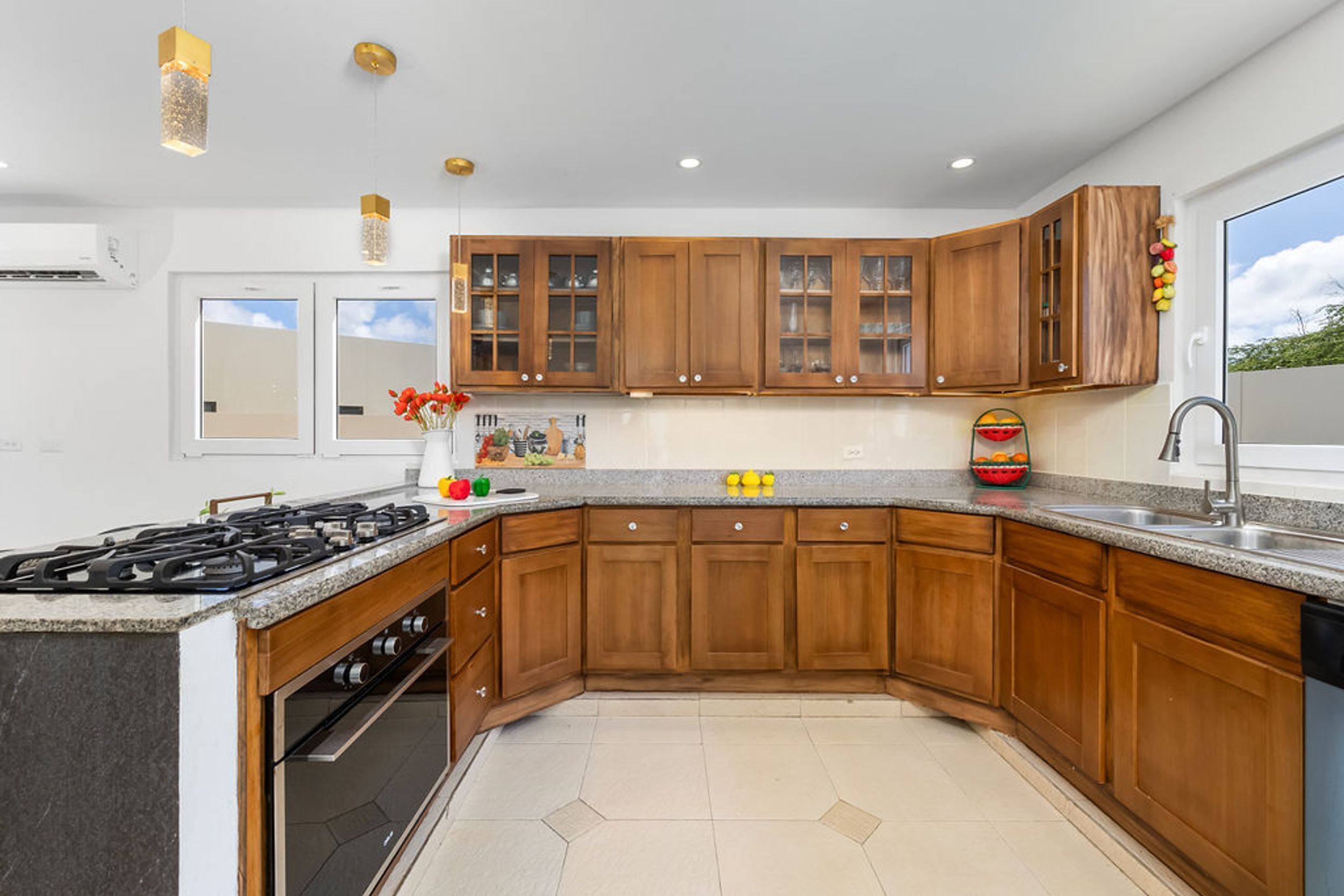 A modern kitchen with wooden cabinets, a granite countertop, and a built-in oven.