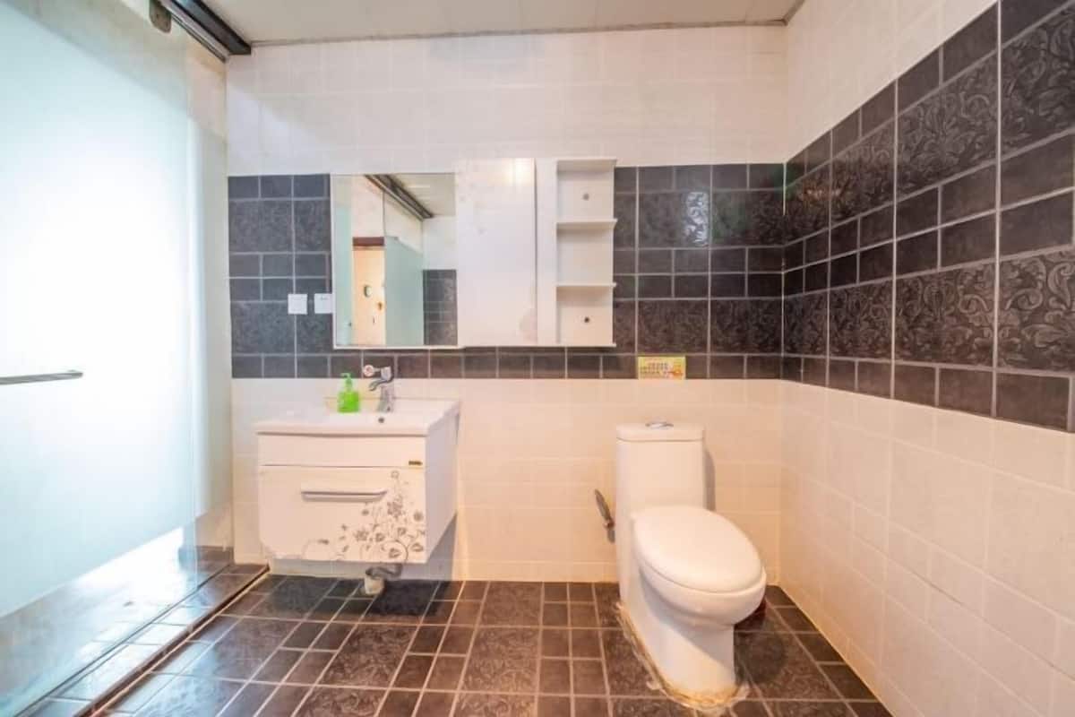 A bathroom with a toilet, sink, and mirror.