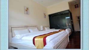 A hotel room with a large bed, a wardrobe, and a mirror. - Shangri-la Xiangruiju Inn (Shangri-La)