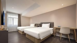 Una camera d'albergo con due letti, una scrivania e una sedia.