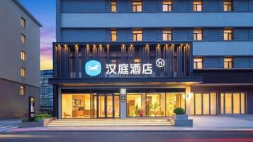 A hotel with a modern facade, illuminated signage, and a well-lit entrance.