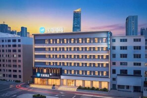 Ein modernes Hotelgebäude mit mehreren Etagen und einer auffälligen Schilder.