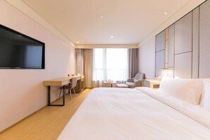 A hotel room with a bed, a desk, a chair, a TV, and a window with curtains. - JI Hotel (Ningbo Beilun Yintaicheng) (Ningbo)