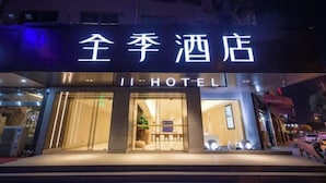 L’entrée d’un hôtel, avec une enseigne indiquant « JI-HOTEL » et des caractères chinois au-dessus.