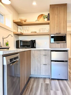 Een moderne keuken met inbouwapparatuur, houten kastjes en een aanrecht.