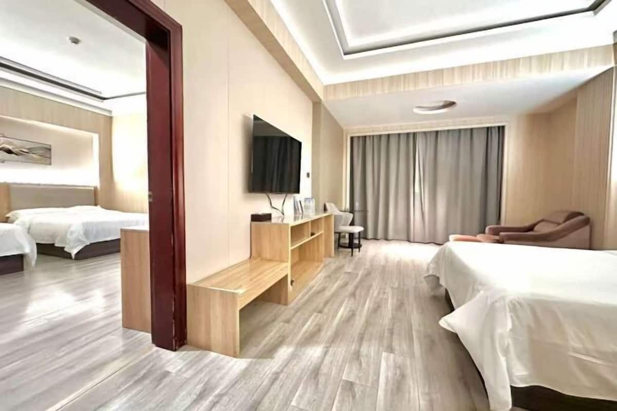 Une chambre d’hôtel avec deux lits, une télévision, un bureau et une chaise.