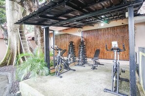 An outdoor gym area with exercise equipment, a bench, and a tree. - Kampung 168 Jimbaran Bali (Bali)