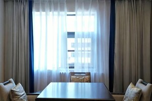 A room with a large window, a table, and two chairs.