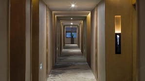 Un pasillo de hotel con suelo de mármol, puertas de madera y un cartel que indica la habitación V411.