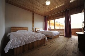 A room with two wooden beds, a wooden ceiling, and a window with curtains. - Shuiyunjian Inn (Yanyuan)