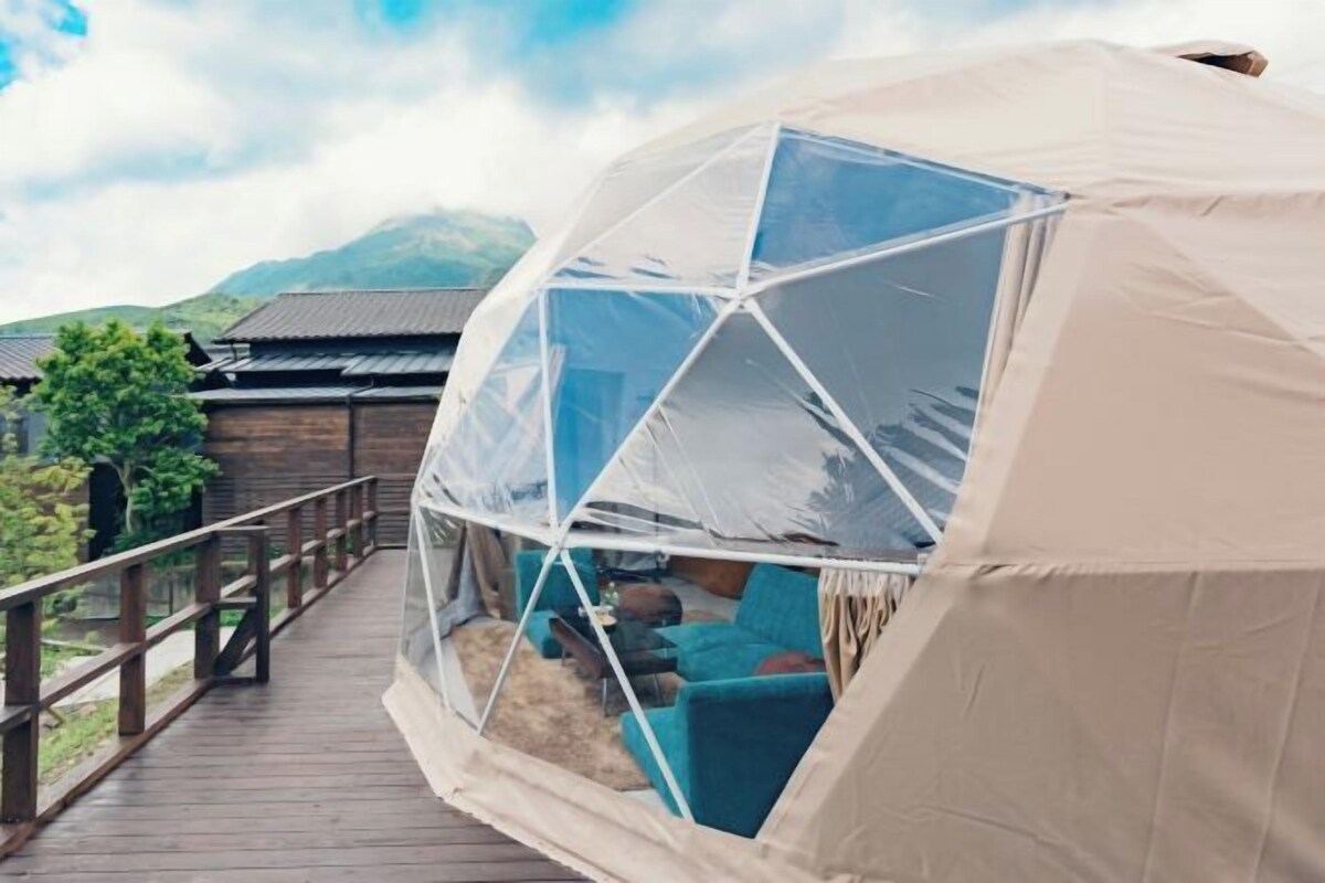 A geodesic dome structure with a wooden deck and seating area.