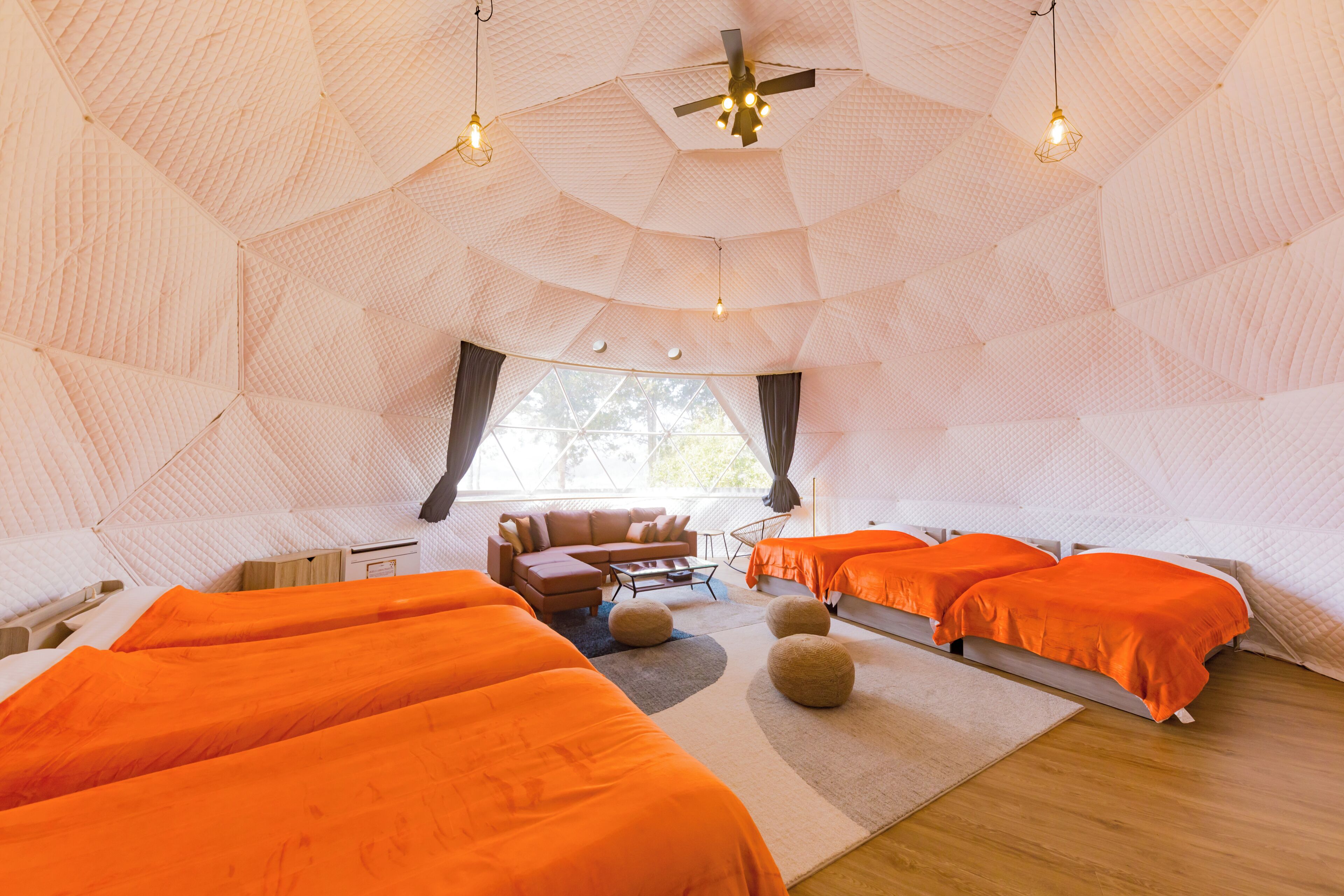 A dome-shaped room with a bed, a sofa, and a coffee table.