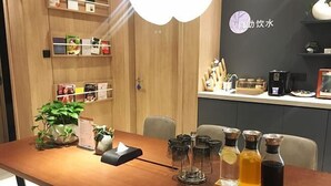 A wooden table with a potted plant, a tissue box, and a tray with glass bottles of beverages. - HanTing Premium Hotel (Wuhan Huake University Innovation Street) (Wuhan)