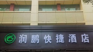 Ein Hotelschild mit chinesischen Schriftzeichen und einem grünen Logo.