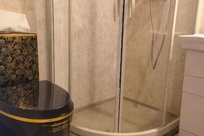 A corner of a bathroom with a glass shower enclosure and a black toilet with gold trim. - Wuxiang Greenrunpeng Express Hotel (Wuxiang)