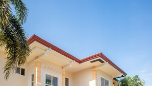A two-story house with a central entrance, a covered porch, and a driveway. - Spacious 5-bedroom Panglao Home with FREE transfers, Infinity Pool, WiFi, & A/C (Panglao)