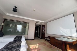 Une chambre d’hôtel avec un lit, un bureau, une grande fenêtre et une porte donnant sur une autre pièce.
