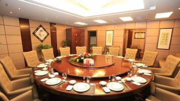 A conference room with a round table, chairs, and a chandelier.