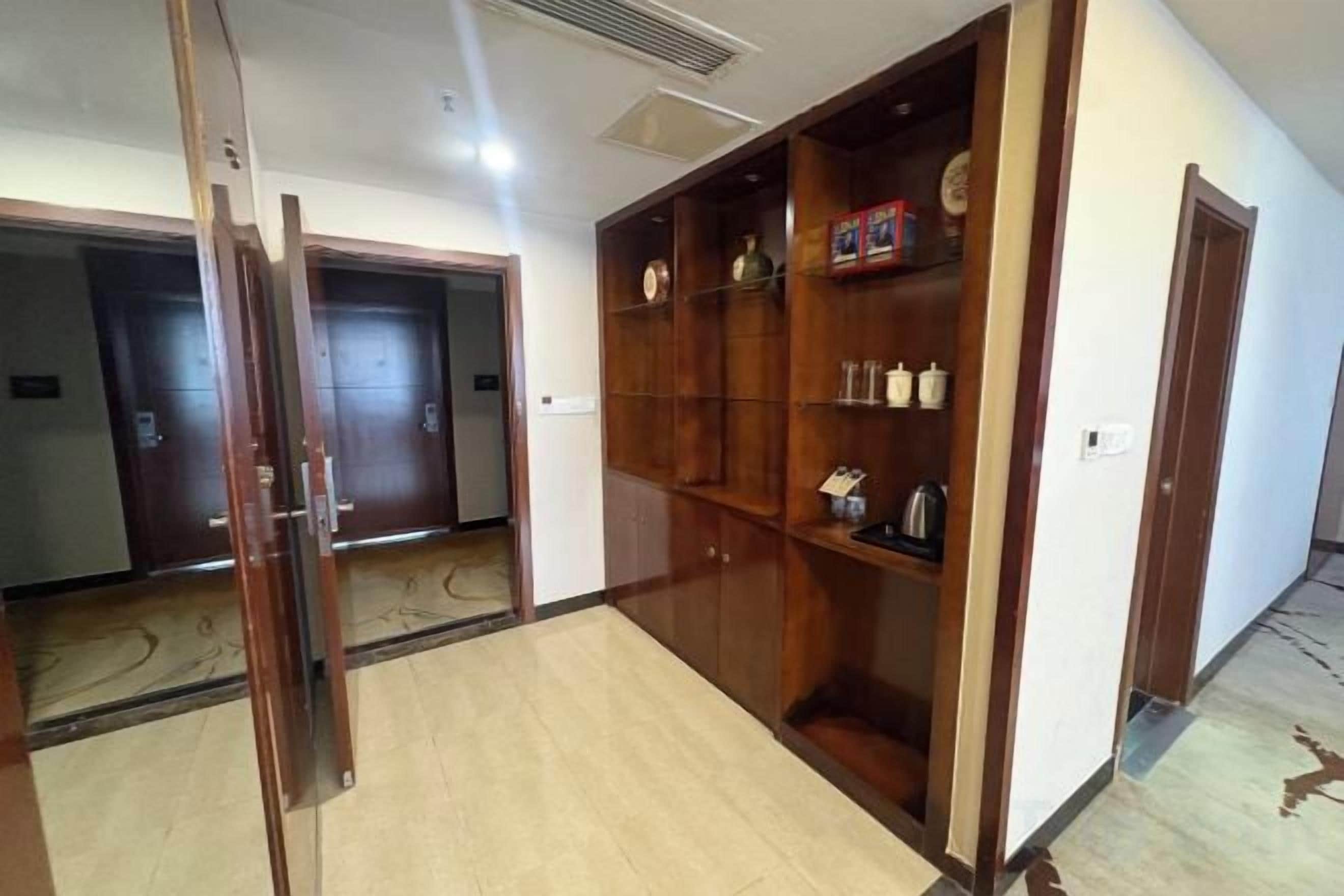 Un pasillo de hotel con puertas de madera y un estante empotrado.