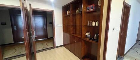 Un pasillo de hotel con puertas de madera y un estante empotrado.