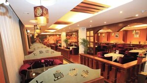 Un restaurant doté de meubles en bois, de luminaires suspendus et d’une décoration d’inspiration asiatique.