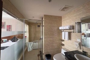Casa de banho moderna com chuveiro, sanita e lavatório.