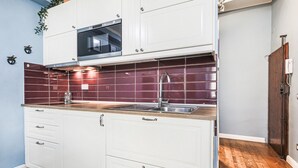 A kitchen with white cabinets, a stainless steel sink, and a microwave. - Apartments Florence - Blue Serendipity (Firenze)