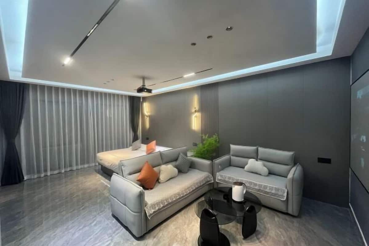 A modern living room with a sectional sofa, a coffee table, and a ceiling light fixture.