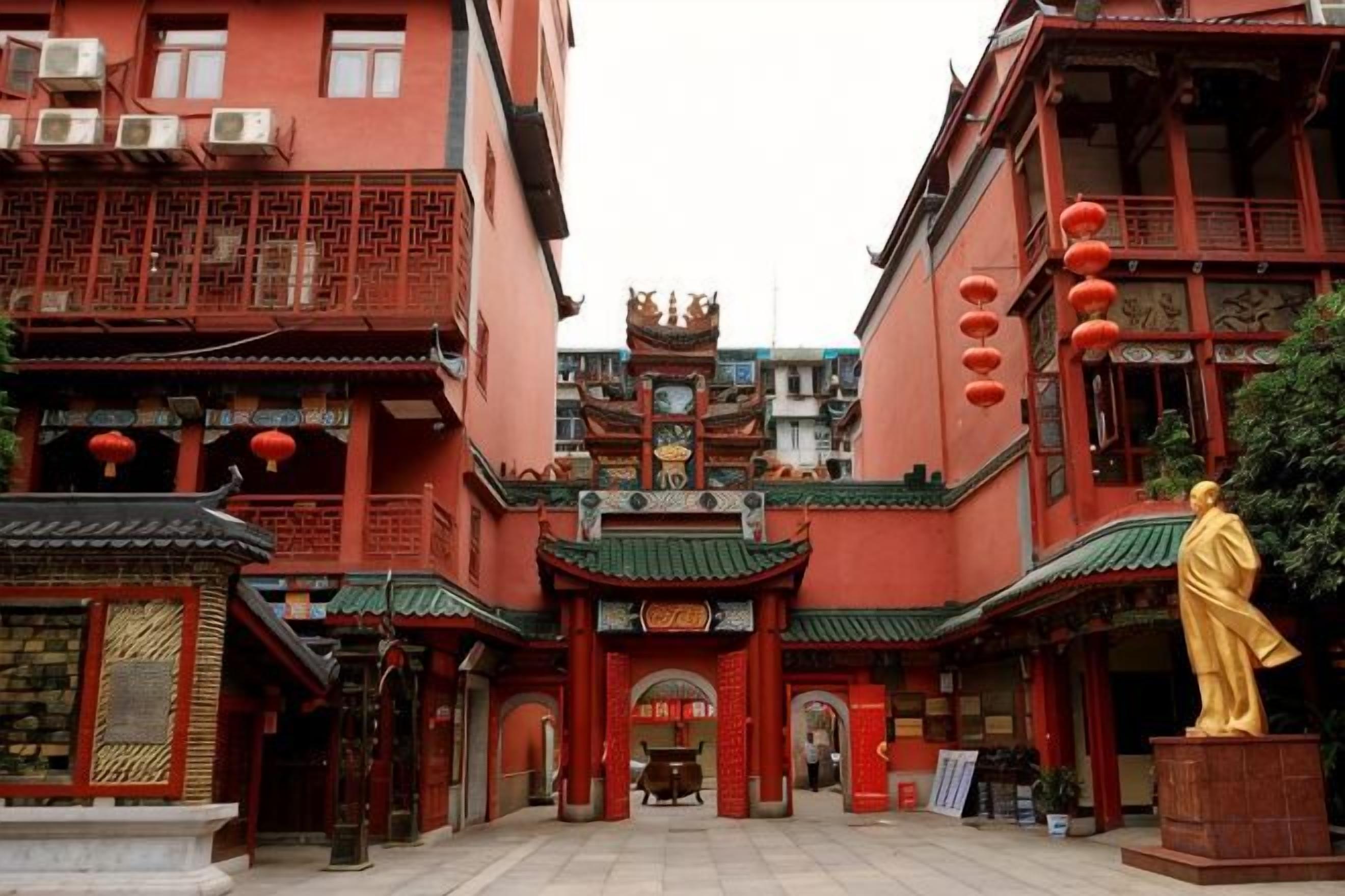 A traditional building with a central entrance, multiple balconies, and a statue.